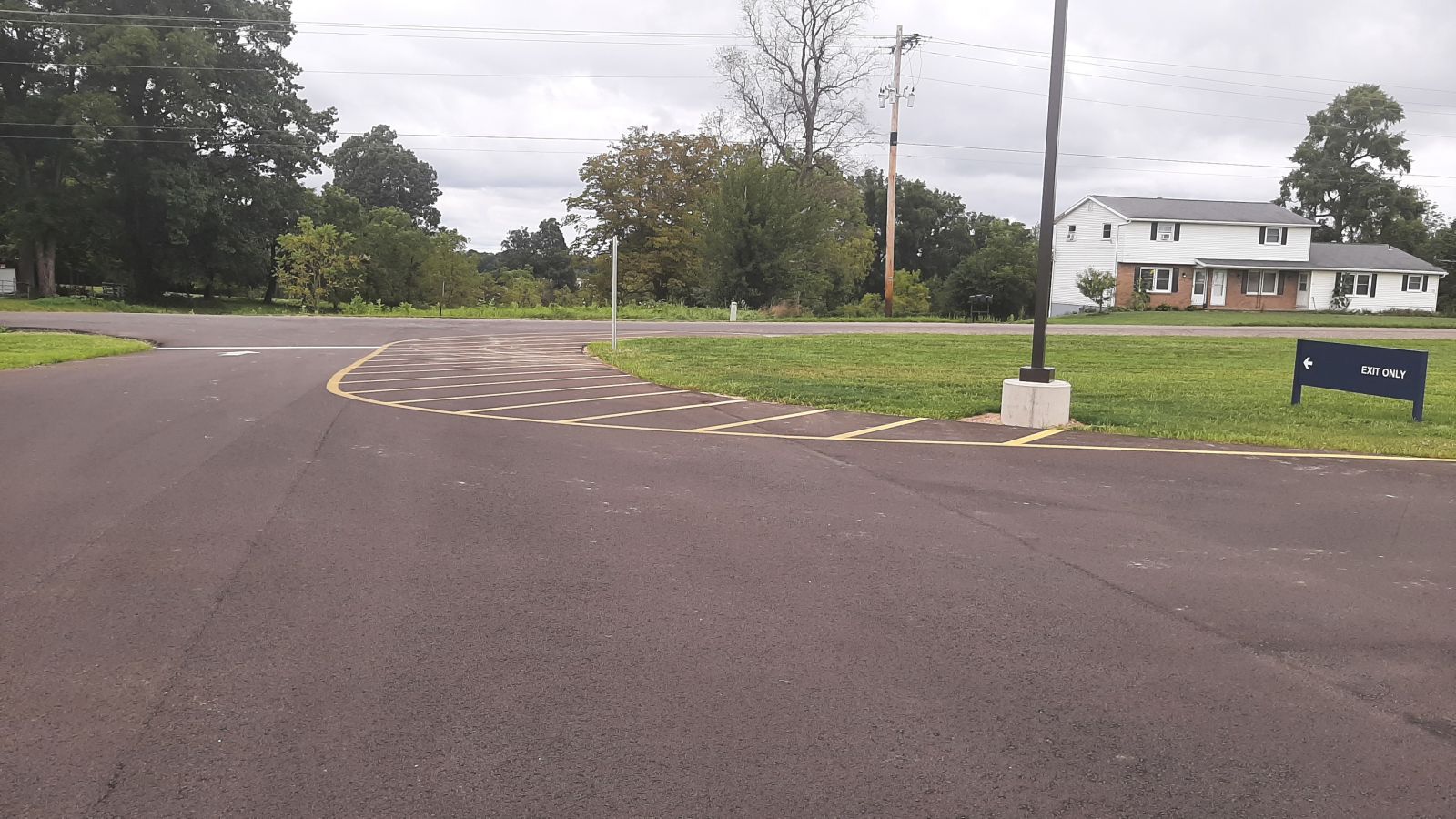 An image of the parking lot, an exit only sign, and painted lines on the blacktop.   