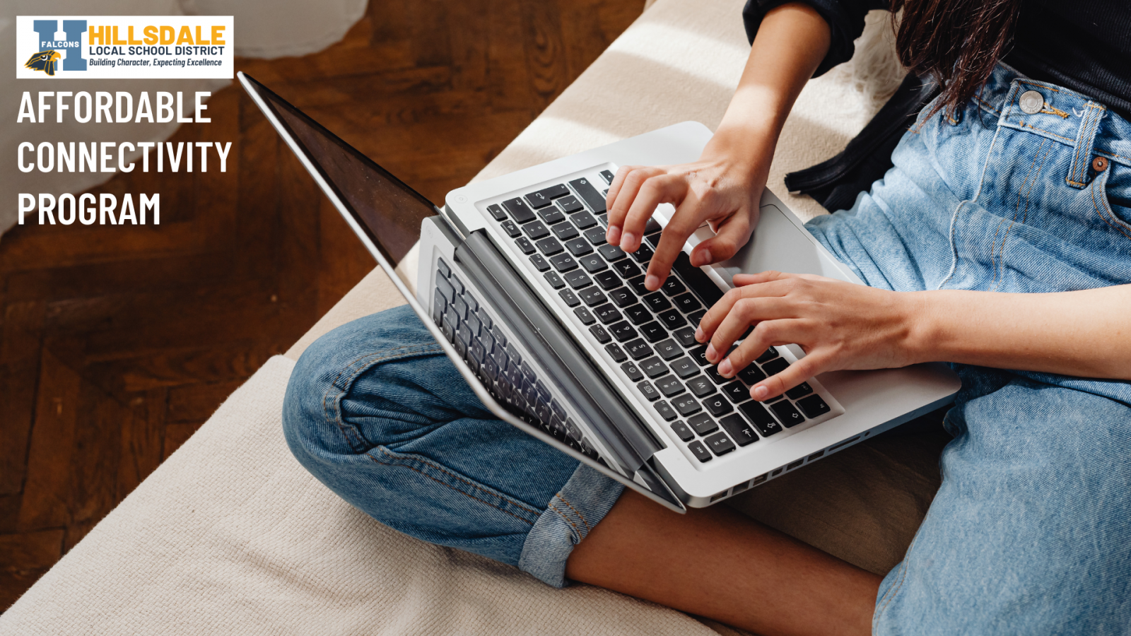An image of an individual typing on a laptop while sitting on a couch.