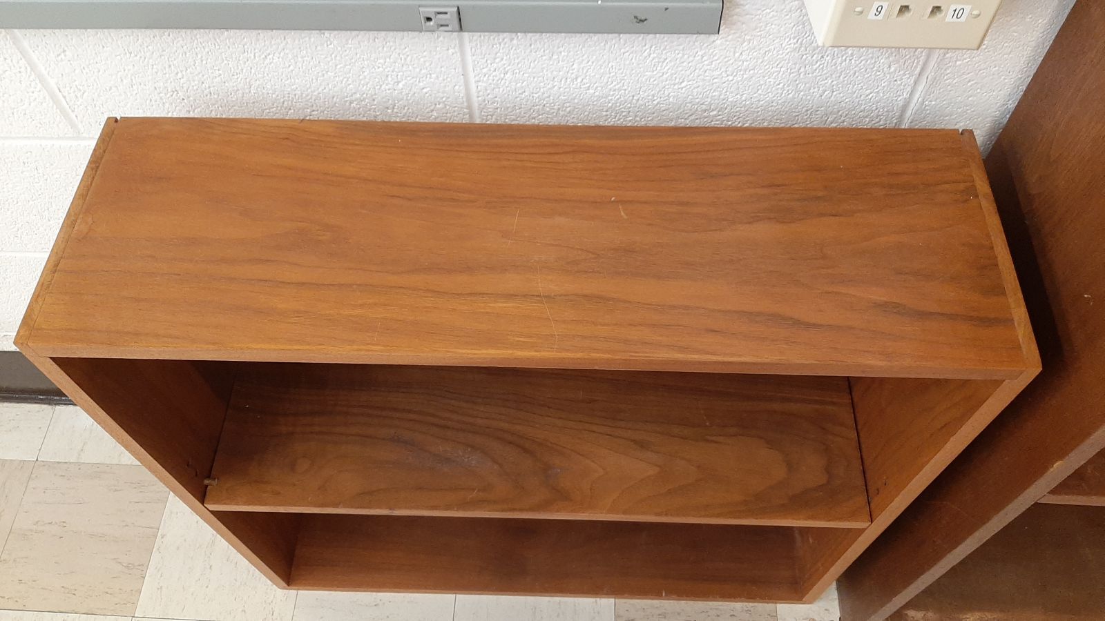 An image of the top of a 2-shelf wood bookcase.