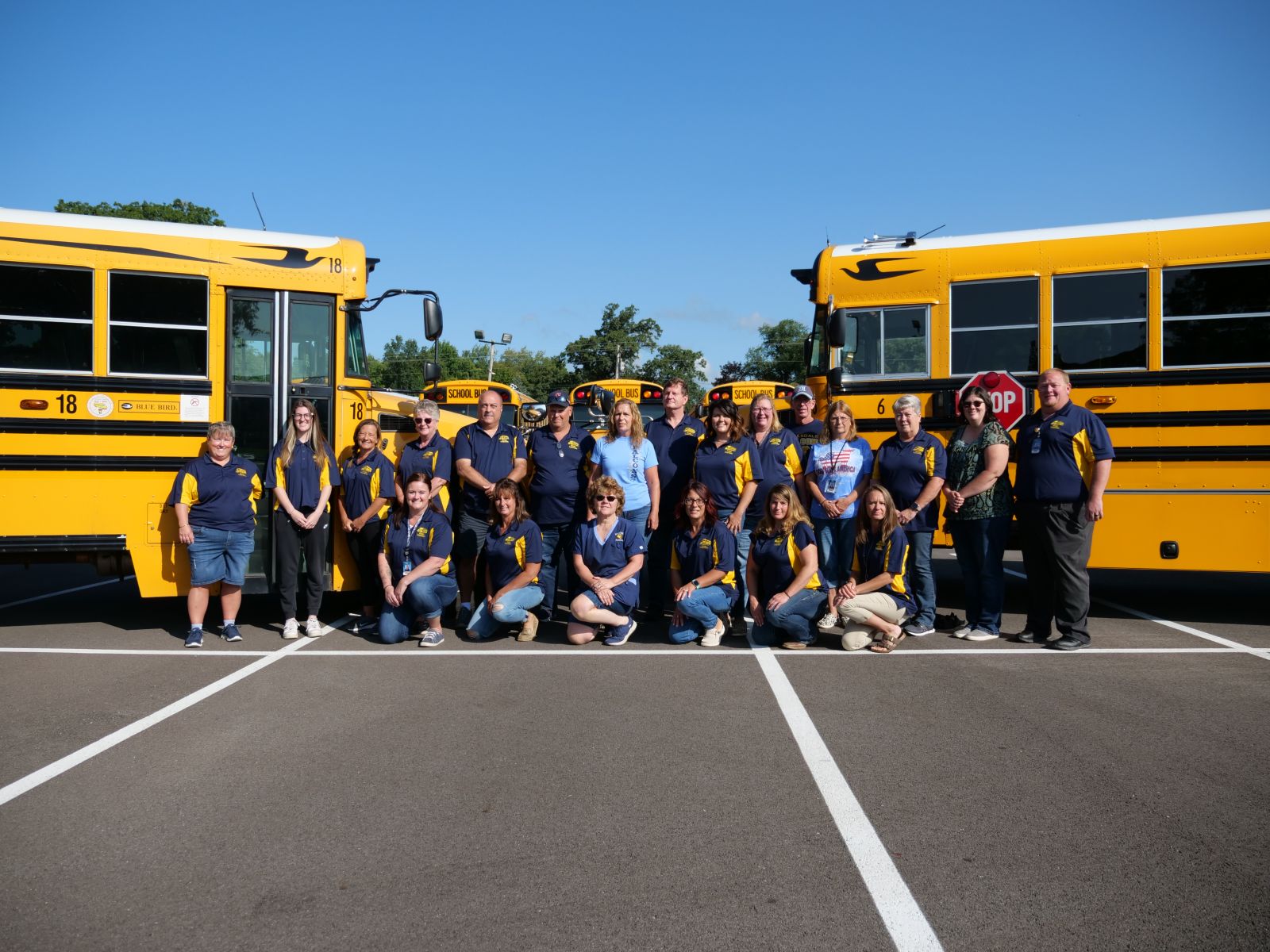 An image of a group of people in front of two buses nose-to-nose.