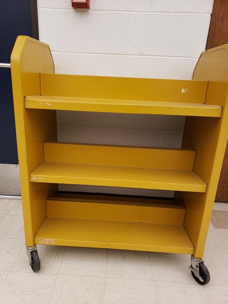 An image of a library book cart in gold.
