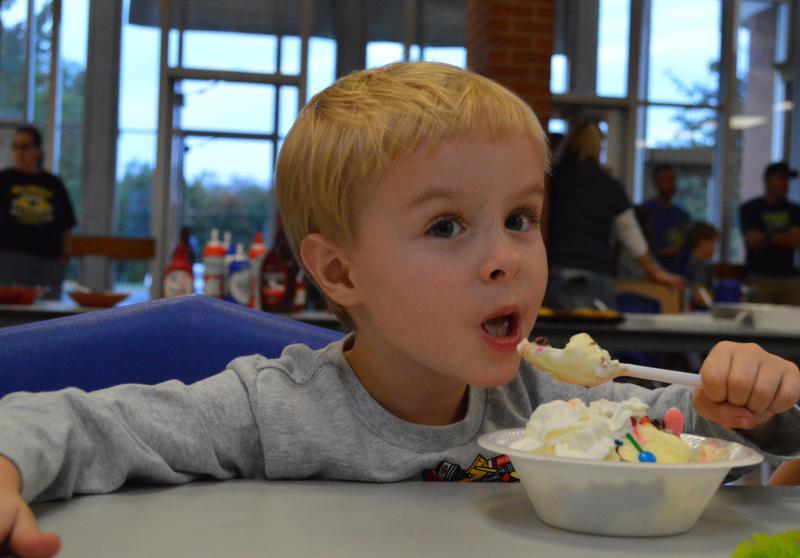 A child eats an ice cream sundae.