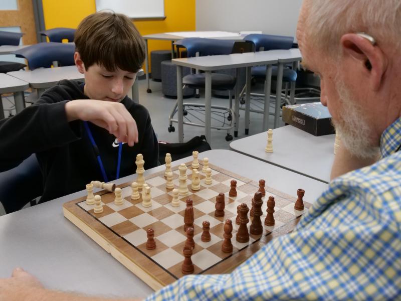 A student and Mr. Locher playing chess.