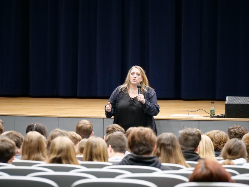 Mrs. Kim Mager speaks to students in the auditorium.
