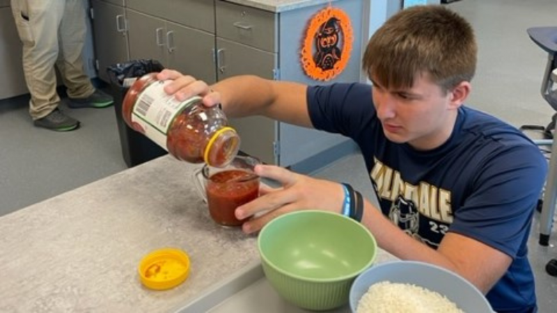 An image of a student measuring salsa at eye level.