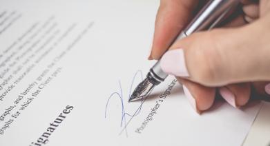 An image of a paper being signed.