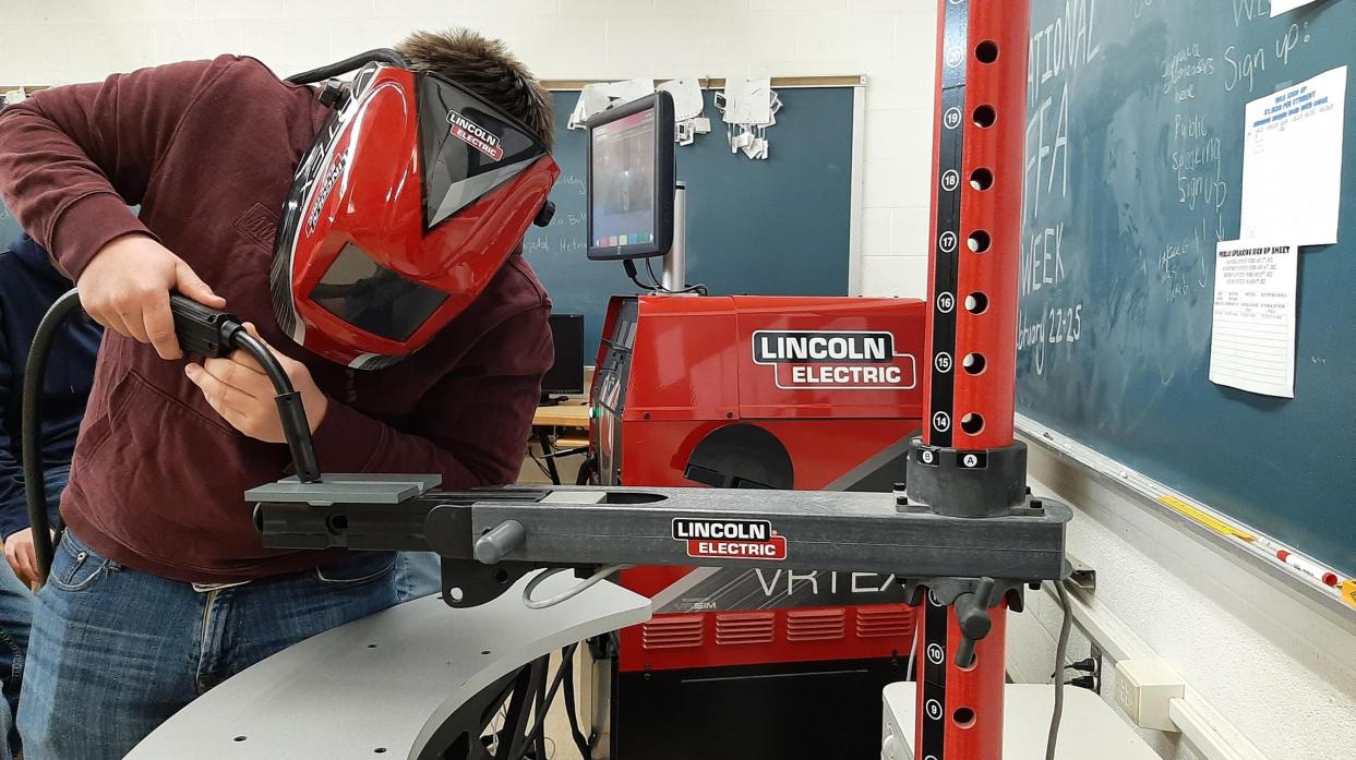 A student operates the virtual welding machine.