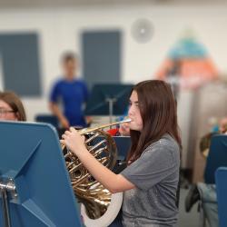 A student plays the French horn.