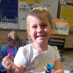 A kindergartener plays with Play-Doh.