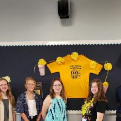 An image of students standing in front of a bulletin board.