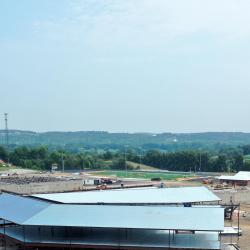 This is a drone photo that shows the steel structure with the steel roof decking of the elementary wing from the long side adjacent to the current building and driveway behind it.