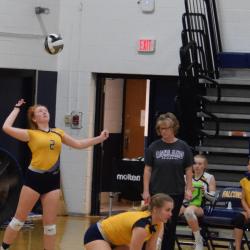 Student-athlete serves ball during volleyball game