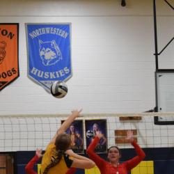 Student-athlete spikes the ball during a volleyball game.