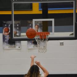 A student shoots a basketball.