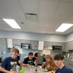 An image of students sitting at a table eating food.