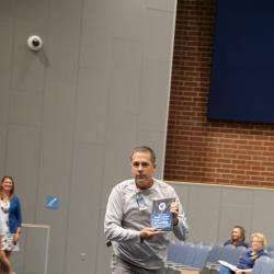 An image of Mr. Hinkle running in the auditorium with his award.