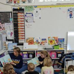 High school students read aloud to elementary students.