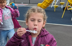 An image of a child blowing bubbles.