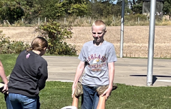Students participate in the wheelbarrow relay.